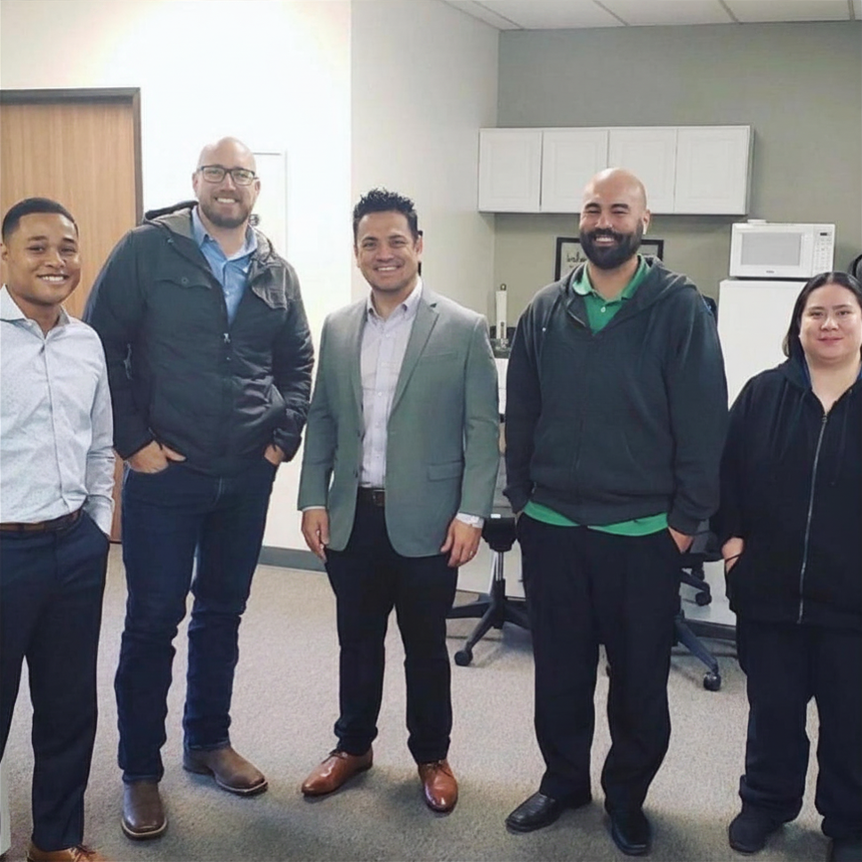 Five IT TechPros team members, including the CEO, smiling together for a team photo